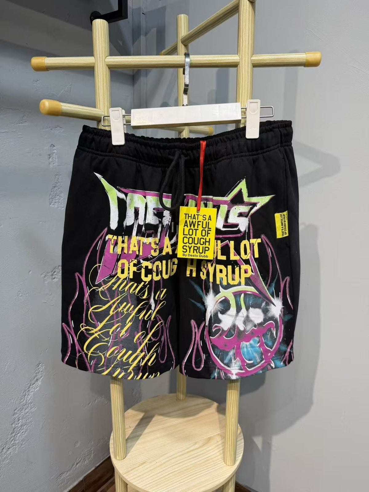 THAT'S A AWFUL LOT OF COUGH SYRUP Black Graphic Drawstring Shorts — front